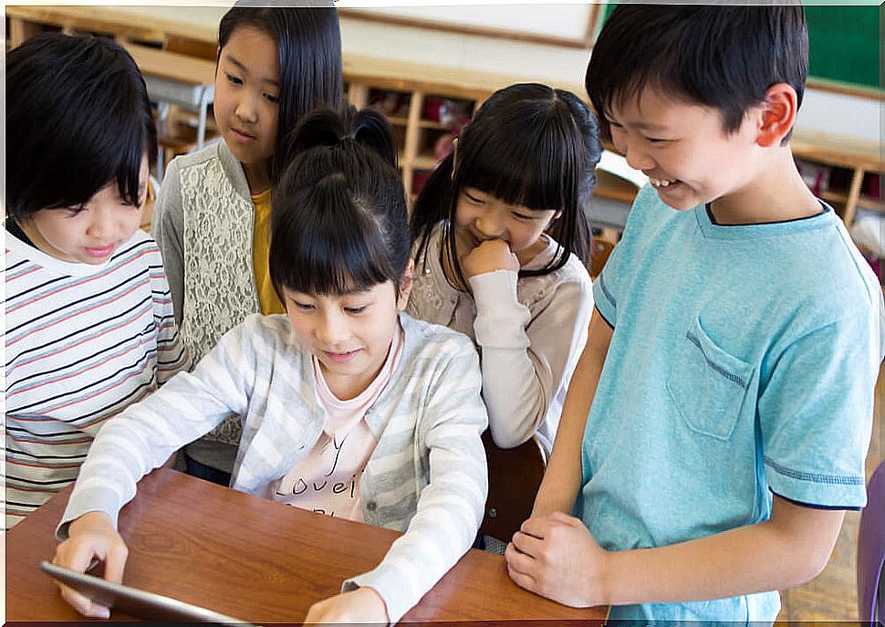 Children in class with a tablet using some children's Apps to learn spelling.