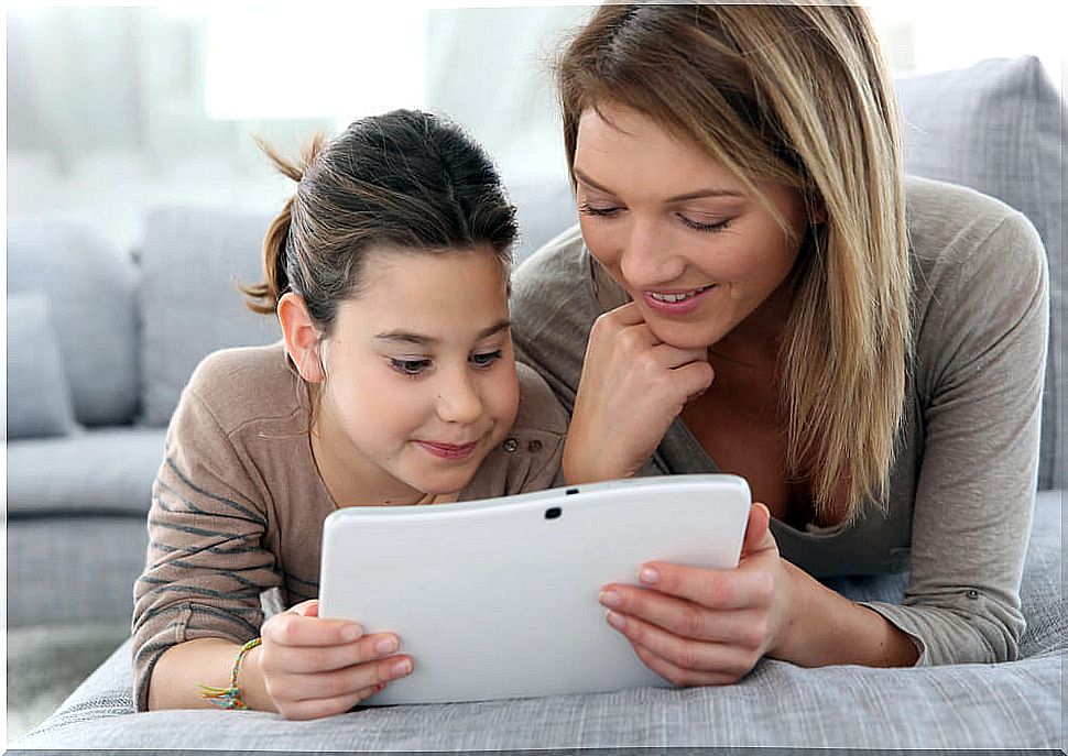 Mother and daughter using some children's Apps to learn spelling on the tablet.