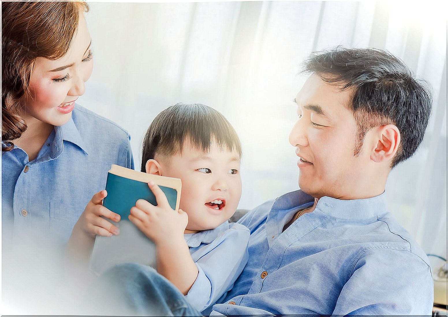 Parents reading to their son in bed.