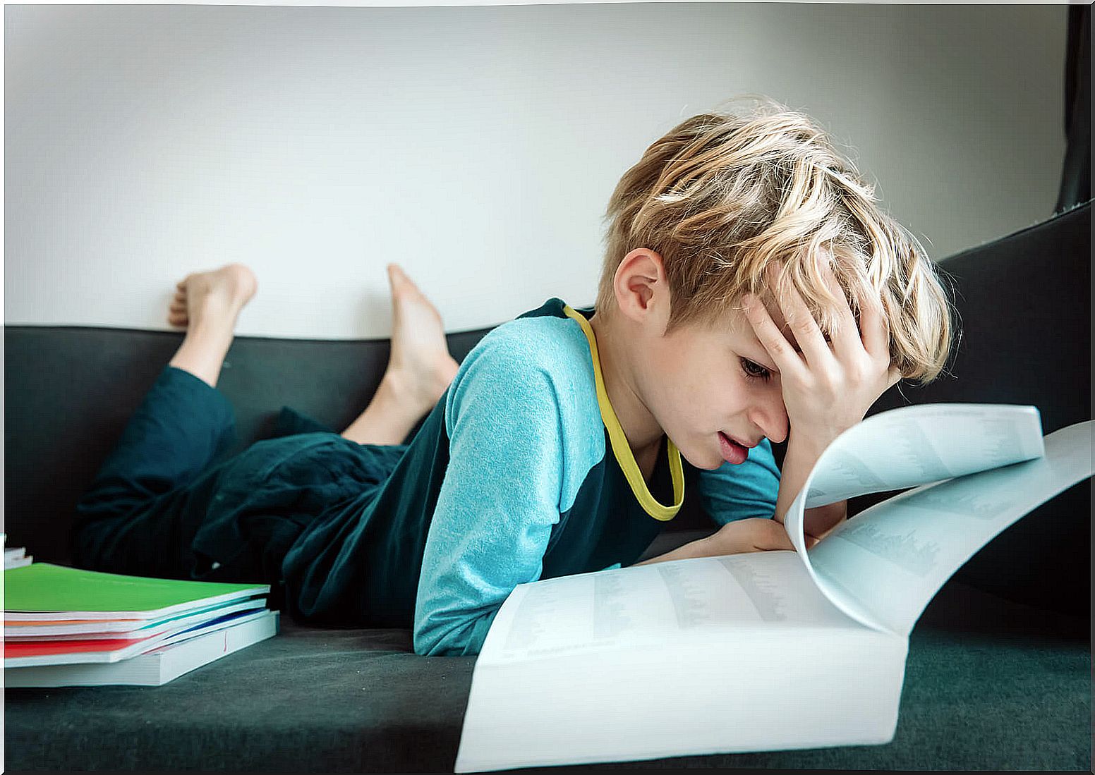 Child on the couch at home with books around who has lost interest in learning.