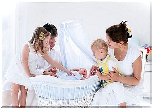 Family around a newborn baby sleeping in a bassinet