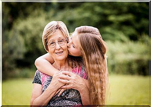 Granddaughter kissing her grandmother with Alzheimer's.