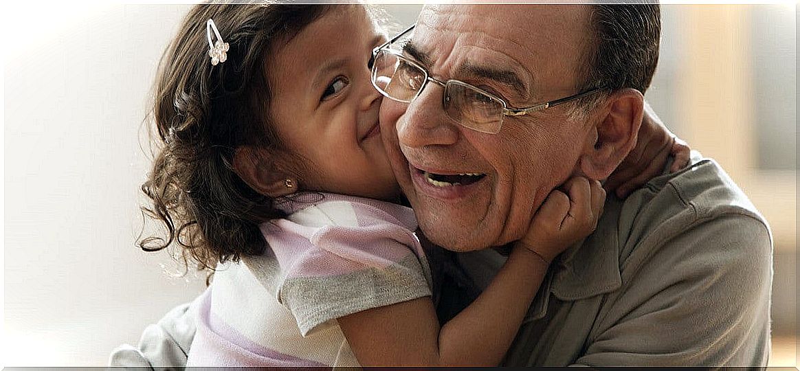 Granddaughter kisses her grandfather, who has Alzheimer's.