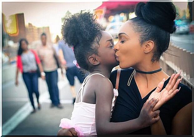 Mother giving her daughter a kiss