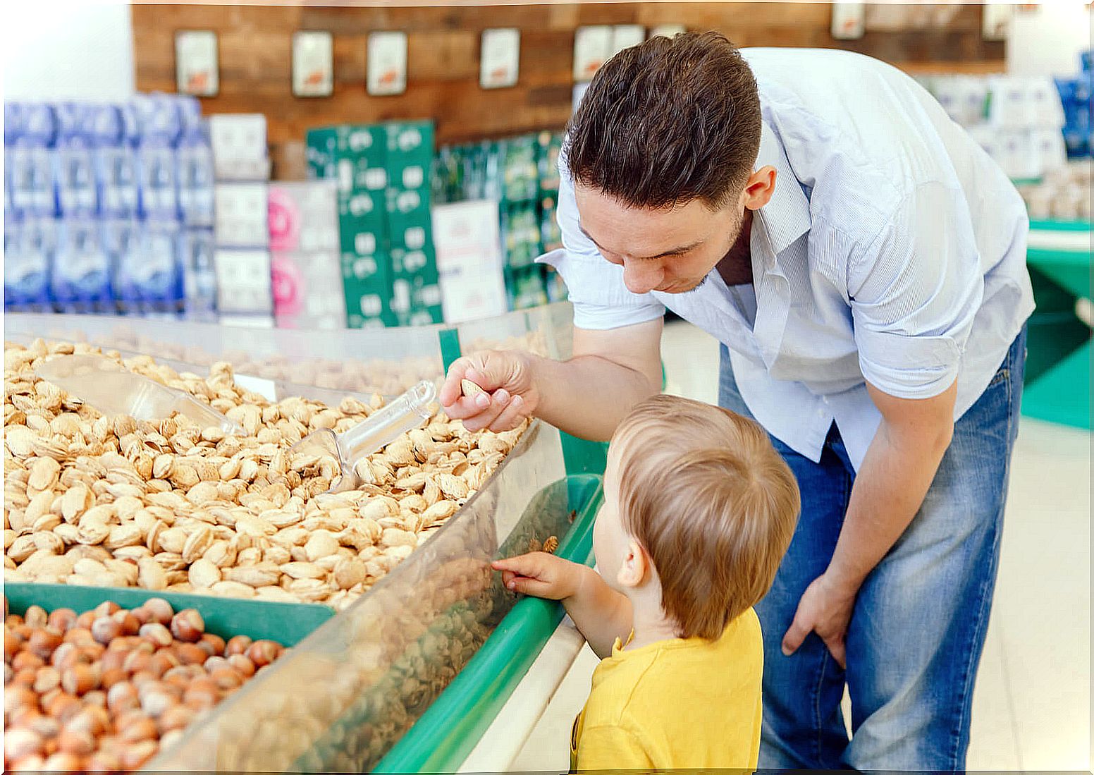 Father with his son buying nuts in bulk.