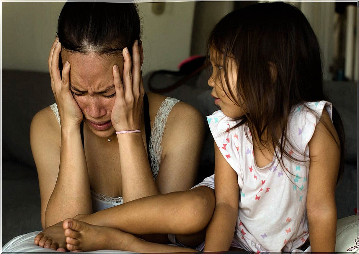 Mother crying in front of her daughter because she suffers from depression.