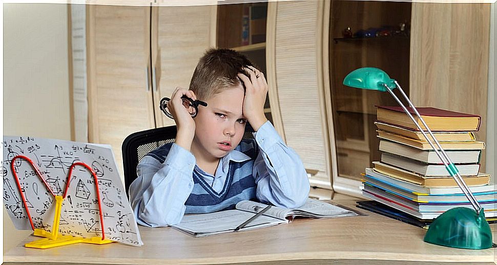 Boy studying in his room with specific learning difficulties and problems.