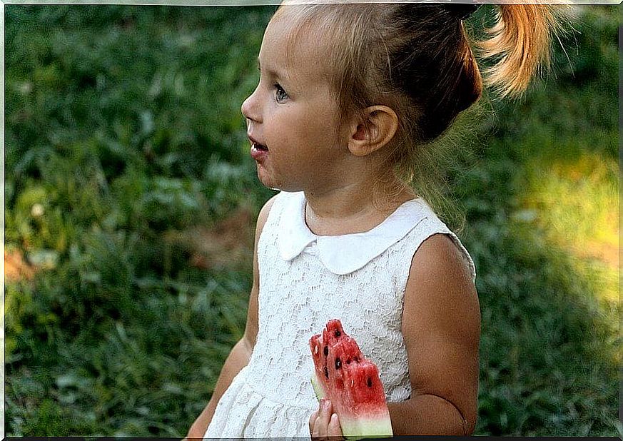 Little girl eating watermelon.