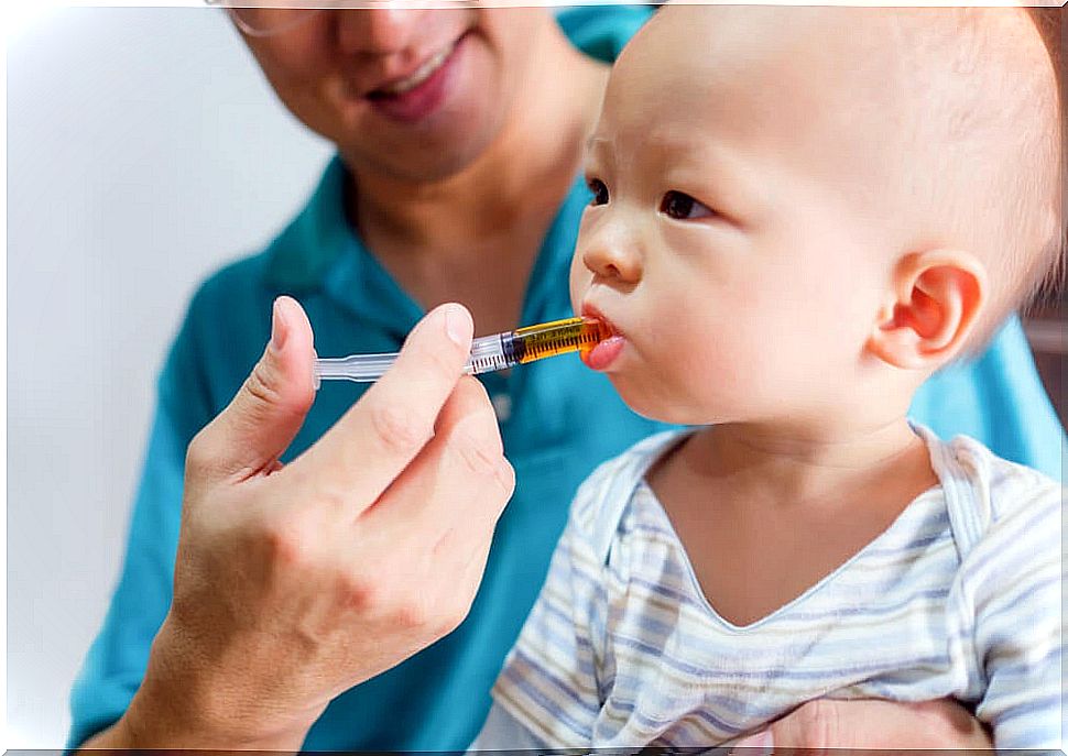 Father learning to give medicine to his son.