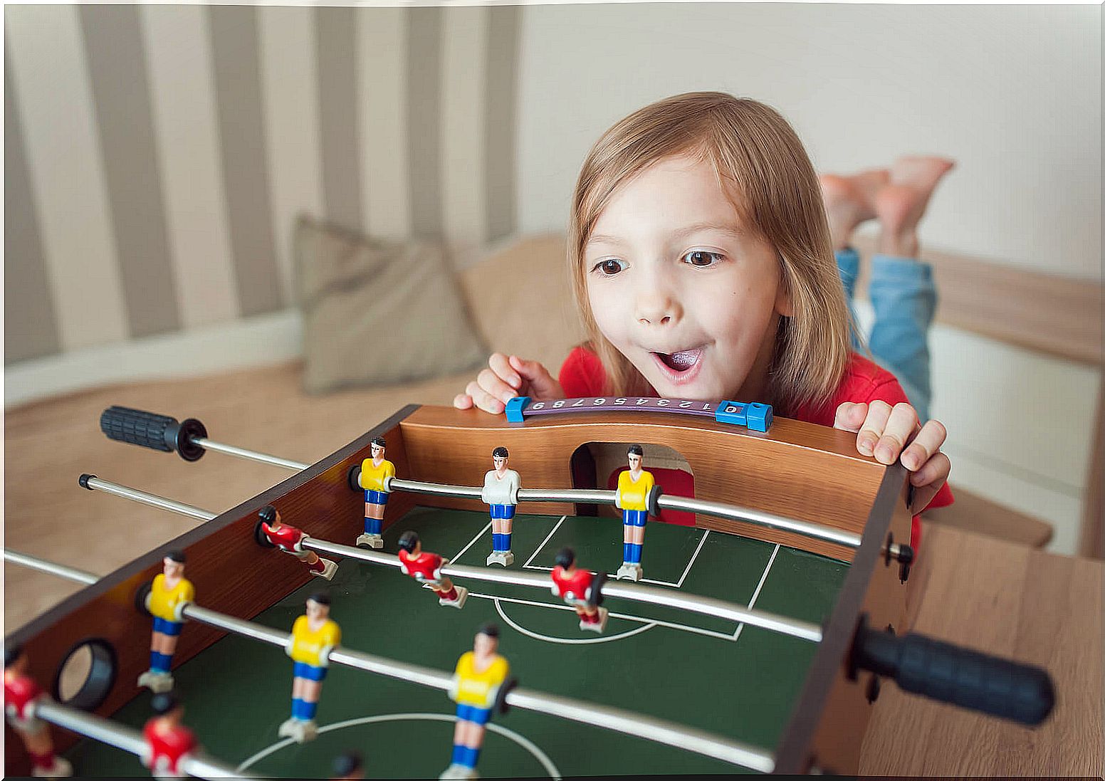 Impulsive girl wanting to play table football.