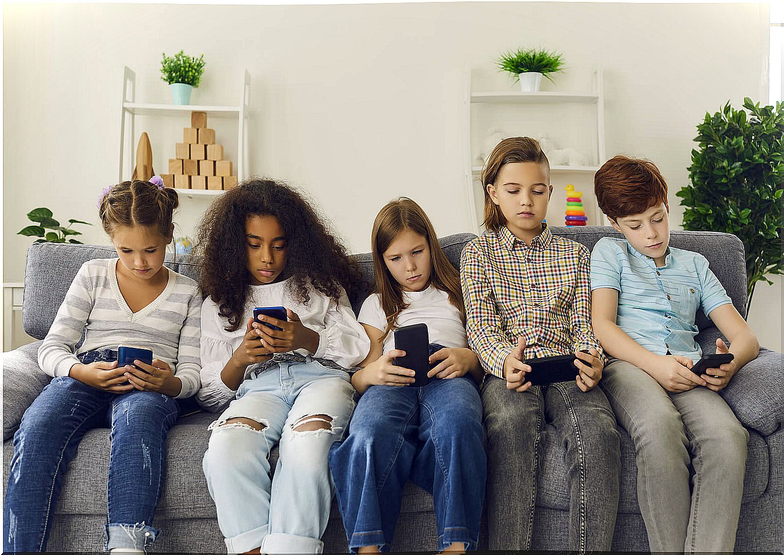 Children not speaking because they are each looking at their mobile phone.