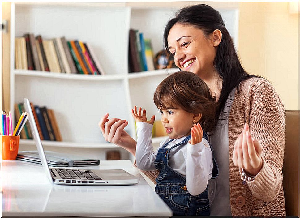 Mother and daughter watching storytelling online during confinement.