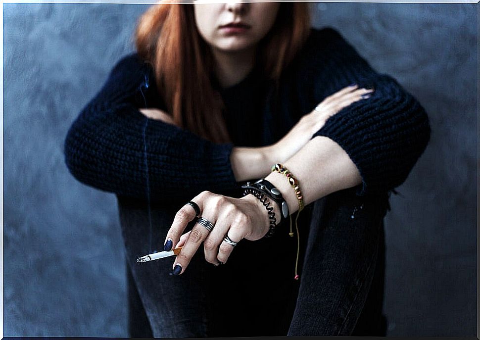 Rebellious teenager smoking a cigarette because his parents are very restrictive.