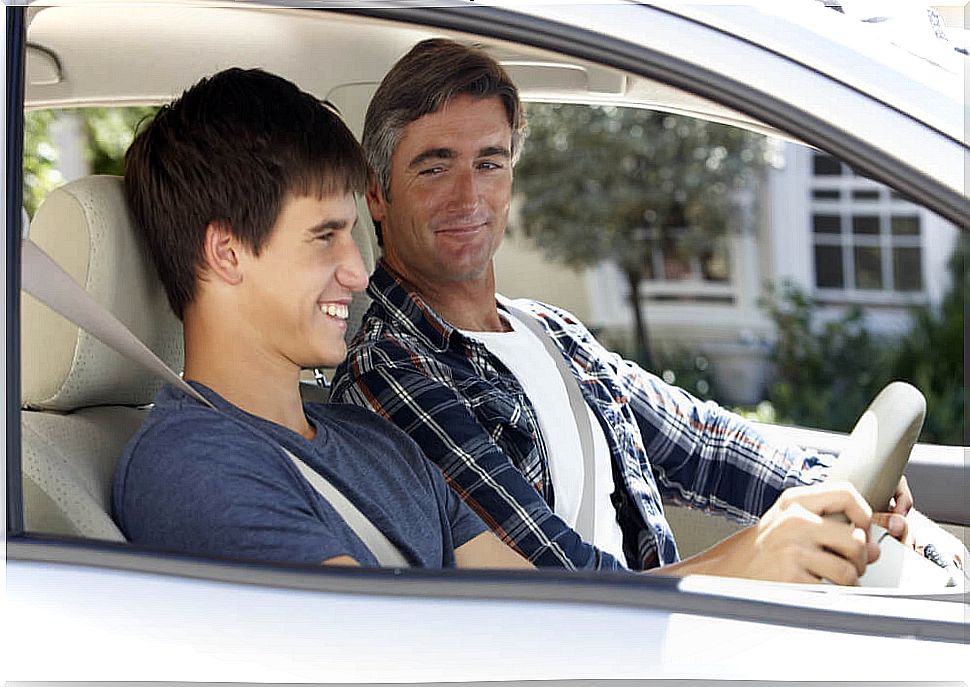 Father teaches his son to drive the car.