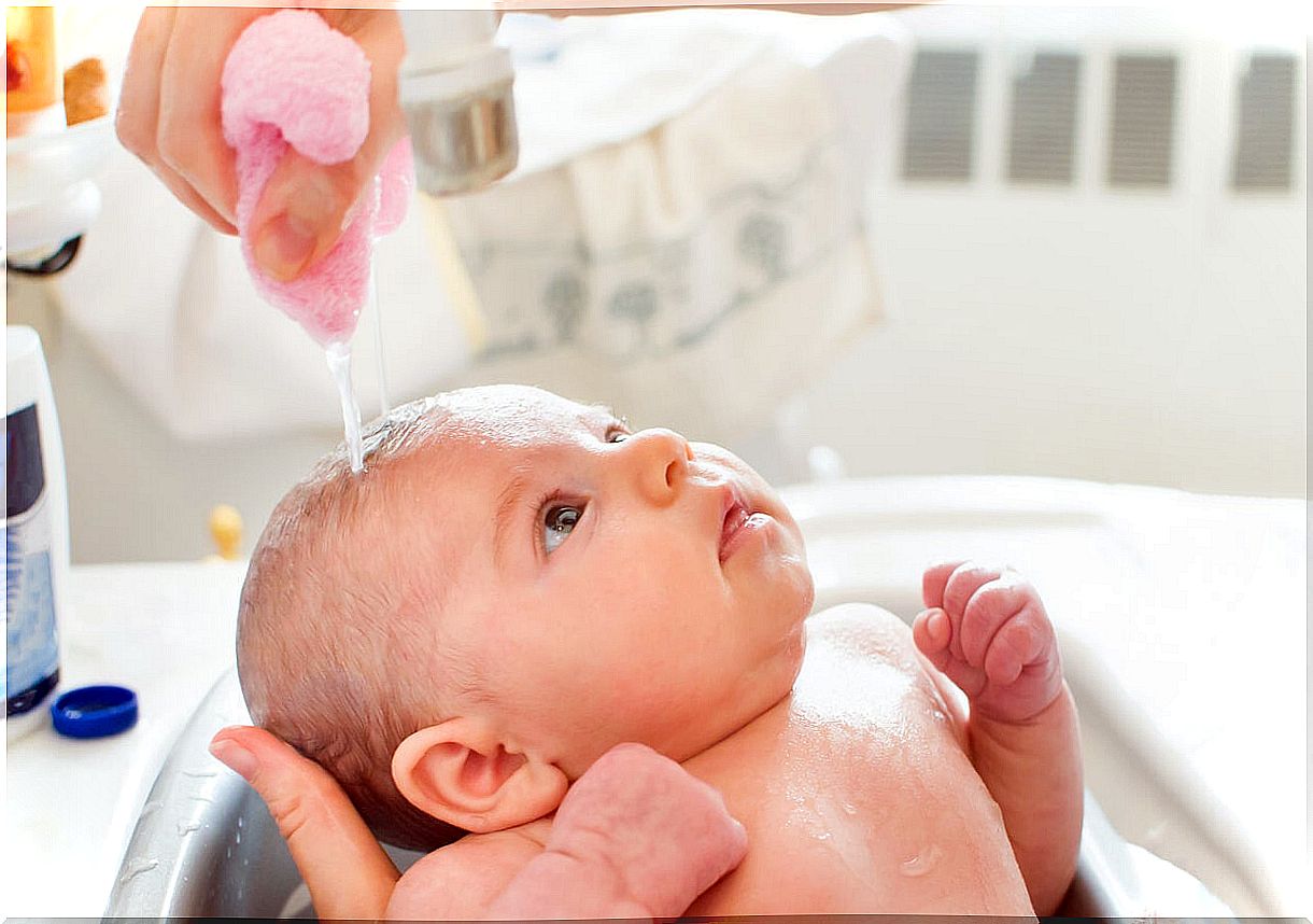 Father giving his newborn a bath.