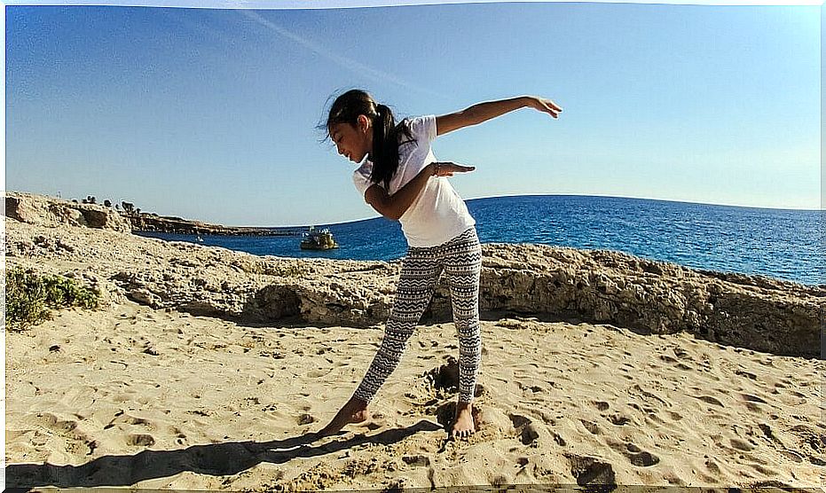 Little girl doing dance on the beach.