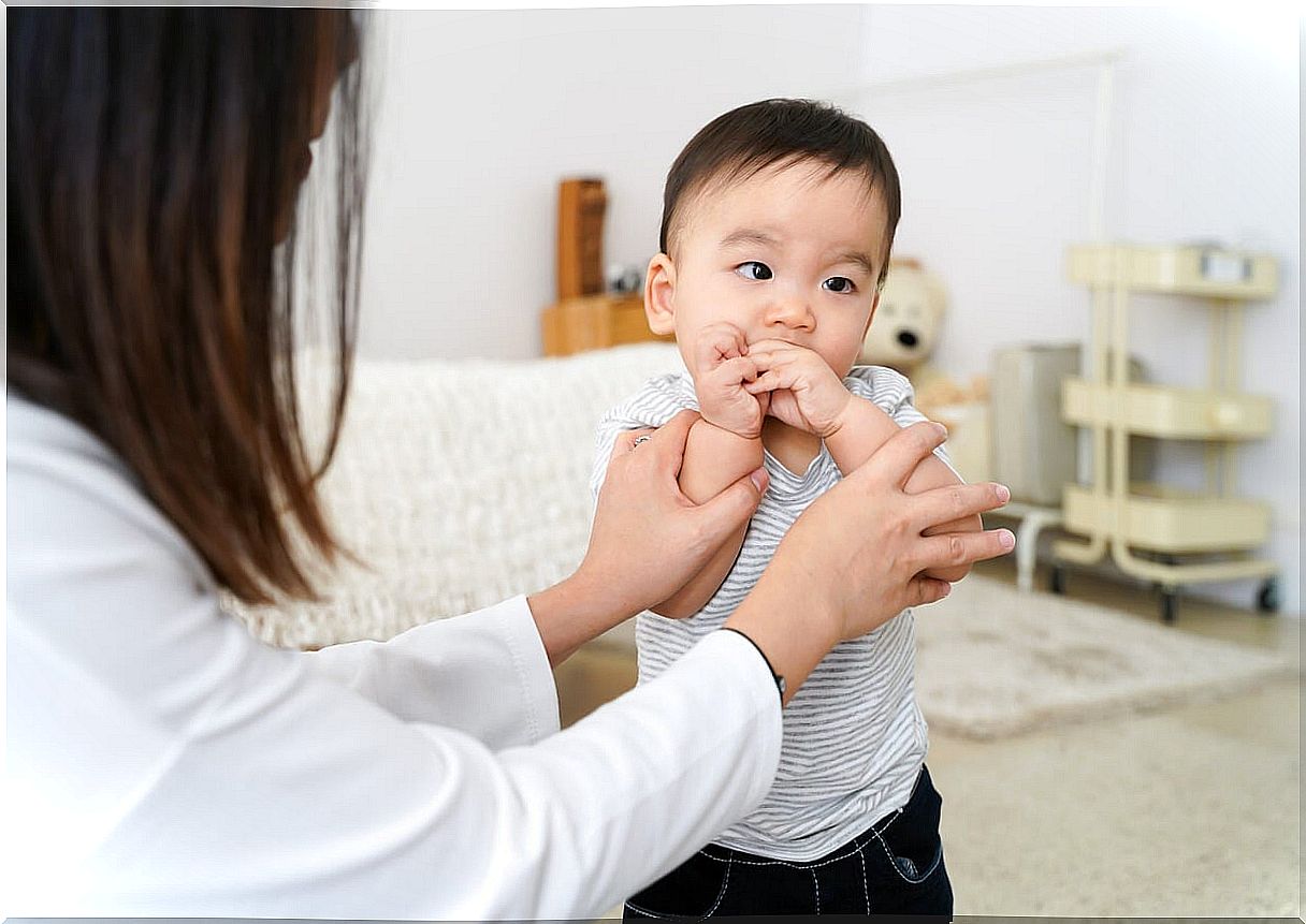 Little boy putting his hands to his mouth.