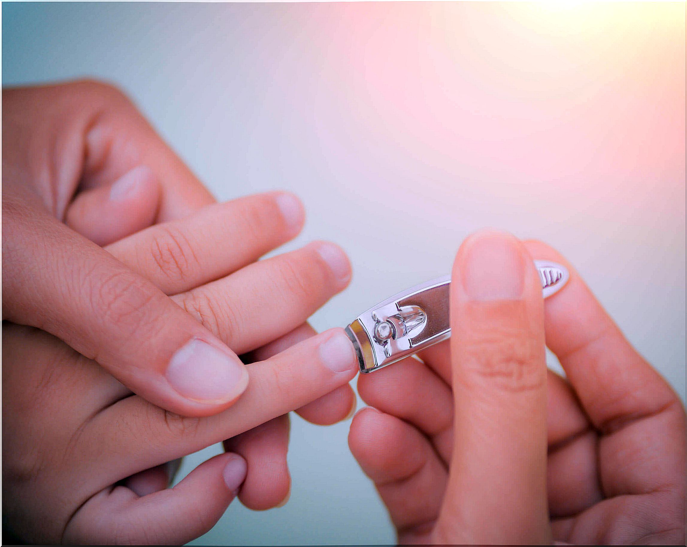 Mother trimming her son's nails to avoid fingernails in babies and children.