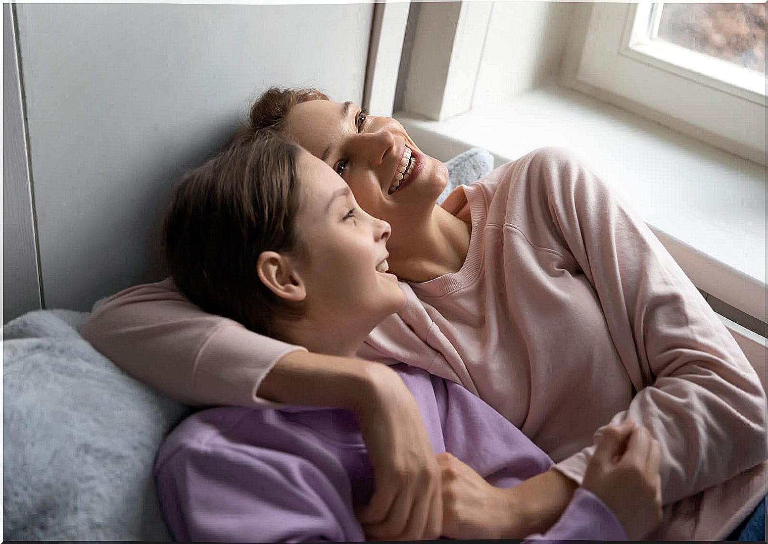 Mother and daughter talking difficult things but smiling.